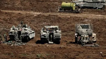 جنود إسرائيليون يقفون بجانب مركبات عسكرية على الجانب الإسرائيلي من الحدود بين إسرائيل ولبنان